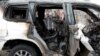 FILE - An Afghan journalist films a damaged vehicle at the site of a blast in Kabul, Afghanistan, Dec. 20, 2020. 