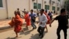 Cambodian Buddhist monks run together with supporters of Cambodian National Rescue Party from a rally site of the Democracy Square in Phnom Penh, Cambodia, Saturday, Jan. 4, 2014. 