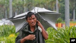 Seorang pria berjalan di tengah hujan di Manila, Filipina, 6 Oktober 2016. Topan Sarika, dengan kecepatan angin 130 kilometer per jam dan menghantam timur laut Filipina.