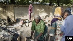 Habiba, une concasseuse de gravier qui pense avoir entre 50 et 60 ans, et Idjele, 38 ans, choisissent des dalles de pierres dans une charrette près de la Cité internationale des affaires à N'Djaména, le 12 avril 2021.