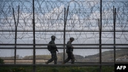 Tentara Korea Selatan berpatroli di sepanjang pagar kawat berduri di Zona Demiliterisasi (DMZ) yang memisahkan Korea Utara dan Selatan, di Pulau Ganghwa Korea Selatan, 23 April 2020. (Foto: AFP)