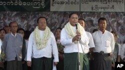 Aung Thein Lin, center, a retired Yangon mayor accompanied by Aung Win, second from left, a candidate of government backed Union Solidarity and Development Party (USDP), speaks to supporters during an election campaign in Dagon Port township, in Yangon,