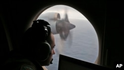 ARSIP – Dalam foto yang diambil pada tanggal 22 Maret 2014 ini, seorang awak penerbang di atas pesawat Royal Australian Air Force, mencari tanda-tanda pesawat Malaysia Airlines no penerbangan MH370 yang hilang di bagian selatan Samudra Hindia lepas pantai Australia. (foto: AP Photo/Rob Griffith, dok.)