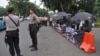 Indonesian police guard the Kamisan protesters, about 100 meters away from the Presidential Palace in Jakarta, Indonesia, July 13, 2017. 