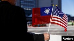Seorang demonstan memegang bendera Taiwan dan AS untuk mendukung Presiden Tsai Ing-wen, di Burlingame, California, AS, 14 Januari 2017.